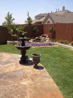 New hardscape and landscape with natural flagstone patio, stone border, trees and shrubs.